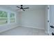 A sunlit bedroom with a ceiling fan, neutral walls, plush carpet, and double windows at 1025 Harrogate Dr, Bessemer City, NC 28016
