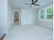 Bright bedroom featuring plush carpet, a ceiling fan, and natural light streaming through the windows at 1025 Harrogate Dr, Bessemer City, NC 28016