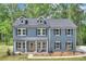 Charming two-story home with blue siding, dormer windows, and inviting front porch in a wooded setting at 1025 Harrogate Dr, Bessemer City, NC 28016