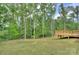 Manicured lawn and deck, ideal for outdoor entertaining, set amidst lush green trees at 1025 Harrogate Dr, Bessemer City, NC 28016
