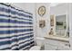 Well-lit bathroom with granite countertop, framed mirror, and decorative blue shower curtain at 107 Hornbeam Ln, Mooresville, NC 28117
