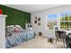 Bedroom with a decorative green wall, plush bedding, and a window desk space at 107 Hornbeam Ln, Mooresville, NC 28117
