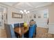 Dining room with coffered ceiling, wood table, elegant chandelier, and wainscoting at 107 Hornbeam Ln, Mooresville, NC 28117