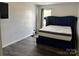 Bedroom with hardwood floors, light-colored walls, and a blue bed at 10826 Claude Freeman Dr, Charlotte, NC 28262