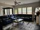 Spacious living room with a plush sectional sofa, stylish rug, and ample natural light through large windows at 10826 Claude Freeman Dr, Charlotte, NC 28262