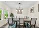 Bright dining room with modern lighting fixture, large window, and stylish decor, perfect for Gathering meals at 11518 Solstice Way, Huntersville, NC 28078