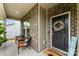Inviting front porch with seating, decorative wreath on front door and welcome mat, showing curb appeal at 11518 Solstice Way, Huntersville, NC 28078