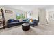 Comfortable living room with sectional sofa, leather ottoman, and natural light from windows at 11518 Solstice Way, Huntersville, NC 28078