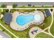 Aerial view of a neighborhood pool with tables, chairs, and a playground surrounded by lush landscaping at 11518 Solstice Way, Huntersville, NC 28078