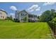 Expansive backyard featuring lush green lawn, deck, and mature trees for privacy at 11718 Preservation Ln, Charlotte, NC 28278