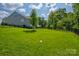 Large backyard with expansive green lawn and mature trees, perfect for outdoor activities at 11718 Preservation Ln, Charlotte, NC 28278