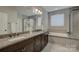 Modern bathroom with double vanity, granite countertops, soaking tub, and tiled shower at 11718 Preservation Ln, Charlotte, NC 28278