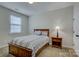 Inviting bedroom features a wood bed frame, a nightstand with a lamp, and a bright window at 11718 Preservation Ln, Charlotte, NC 28278