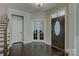 Bright foyer with hardwood floors, staircase, and French doors at 11718 Preservation Ln, Charlotte, NC 28278