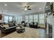 Open-concept living room with dark wood floors, fireplace, and large windows at 11718 Preservation Ln, Charlotte, NC 28278