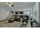 Open-concept living room with dark wood floors, fireplace, and seamless flow to kitchen at 11718 Preservation Ln, Charlotte, NC 28278