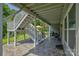 Covered patio offers shade and outdoor living space with stairs to the backyard at 11718 Preservation Ln, Charlotte, NC 28278