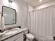 Bright bathroom featuring a granite countertop, modern fixtures, and a shower with white shower curtain at 13421 Copley Square Dr, Huntersville, NC 28078