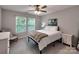 Cozy bedroom featuring two windows, a ceiling fan, and neutral decor at 13421 Copley Square Dr, Huntersville, NC 28078