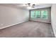 Bonus room features plush carpeting, neutral walls and ample natural light at 13421 Copley Square Dr, Huntersville, NC 28078