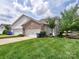Charming exterior with a well-maintained lawn, two-car garage, and beautiful landscaping at 13421 Copley Square Dr, Huntersville, NC 28078