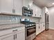 This bright kitchen features stainless steel appliances, white shaker cabinets, and granite countertops at 13421 Copley Square Dr, Huntersville, NC 28078