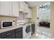 A cozy kitchen features white upper cabinets, contrasting dark lower cabinets, and modern appliances at 1457 Matthew Allen Cir, Kannapolis, NC 28081