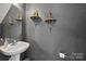 Stylish powder room with decorative shelves, gray walls, pedestal sink, and elegant mirror at 1457 Matthew Allen Cir, Kannapolis, NC 28081