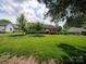 Spacious backyard with green grass, mature trees, offering a serene outdoor living area at 1505 Moss Springs Rd, Albemarle, NC 28001
