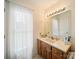 Bright bathroom featuring a large window and vanity with a large framed mirror at 1505 Moss Springs Rd, Albemarle, NC 28001