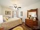 Bedroom featuring hardwood floors, a ceiling fan, a window, and a dresser with a mirror at 1505 Moss Springs Rd, Albemarle, NC 28001