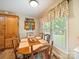 Dining area with a wood table, seating for six, and a window with colorful floral valance at 1505 Moss Springs Rd, Albemarle, NC 28001