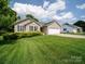 Single-story home featuring a well-manicured lawn, tidy landscaping, and an attached two-car garage under a bright sky at 1505 Moss Springs Rd, Albemarle, NC 28001