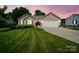 Charming single-story home featuring a well-manicured lawn and an attached two-car garage with a beautiful sunset backdrop at 1505 Moss Springs Rd, Albemarle, NC 28001