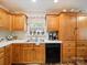 Traditional kitchen with wooden cabinets, stainless sink, black dishwasher, and window view at 1505 Moss Springs Rd, Albemarle, NC 28001