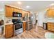 Kitchen featuring stainless steel appliances, wooden cabinetry, and wood-look flooring at 1505 Moss Springs Rd, Albemarle, NC 28001