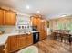 Eat-in kitchen with wood cabinetry, stainless sink, black dishwasher, table, and wood-look flooring at 1505 Moss Springs Rd, Albemarle, NC 28001