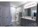 Well-lit bathroom with double vanity, framed mirror, and a glass-enclosed shower at 177 Willow Valley Dr, Mooresville, NC 28115