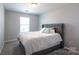 Inviting bedroom with a gray upholstered headboard, soft carpet, and natural light at 177 Willow Valley Dr, Mooresville, NC 28115