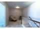 Upstairs hallway sitting area featuring a rocking chair, small table, and railing at 177 Willow Valley Dr, Mooresville, NC 28115