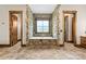 A unique bathtub is framed by stone walls and flanked by doorways, complemented by neutral tile flooring at 1822 Irby Rd, Monroe, NC 28112