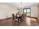 Open dining room features a wood table, leather chairs, hardwood flooring, and exterior view windows at 1822 Irby Rd, Monroe, NC 28112