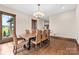 Elegant dining room with a wooden table, leather chairs, chandelier lighting and a view of the outdoors at 1822 Irby Rd, Monroe, NC 28112