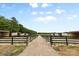 Equestrian property featuring multiple horse stables and fencing along a gravel path at 1822 Irby Rd, Monroe, NC 28112