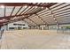 Large indoor riding arena with sand floor, metal beam ceiling, and multiple windows at 1822 Irby Rd, Monroe, NC 28112