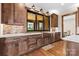 Kitchen featuring wood cabinets, mosaic backsplash, stone countertops, and farmhouse sink at 1822 Irby Rd, Monroe, NC 28112