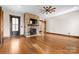 A spacious living room showcases a stone fireplace with a mounted TV and hardwood floors illuminated by natural light at 1822 Irby Rd, Monroe, NC 28112
