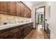 Pantry with custom wood cabinets and marble countertops with view to a dining area at 1822 Irby Rd, Monroe, NC 28112