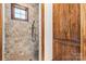 Stone shower with rustic wood door and window at 1822 Irby Rd, Monroe, NC 28112