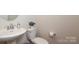 Neutral-toned bathroom featuring a white toilet, sink, and a plant to add character to the area at 1914 Loggerhead Dr, Lancaster, SC 29720